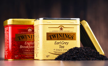 Twinings Earl Grey and English Breakfast - 2 tea caddies behind each other, with a pile of black tea in front,