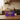 AI gegenereerd beeld van een doosje Twinings Darjeeling 25 zakjes, in een keuken met een koperen fluitketel op het fornuis.
